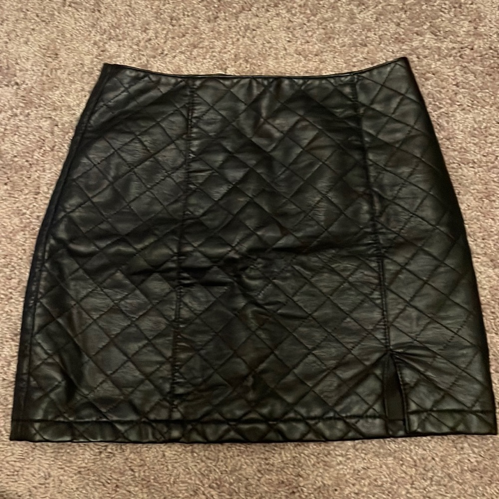 Black leather mini skirt with mini slit on left leg.